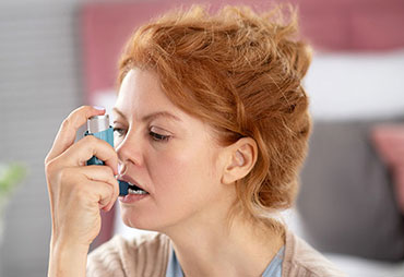 Woman using inhaler for asthma